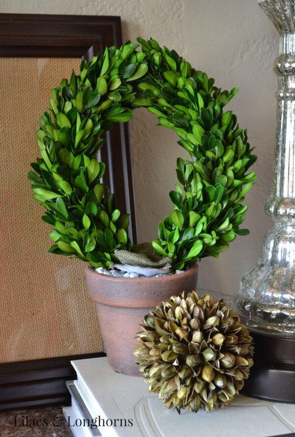 A cute little boxwood topiary adds some color and interest to this foyer table vignette.