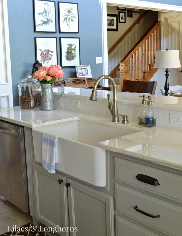 farm sink and marble counters in farmhouse traditional kitchen